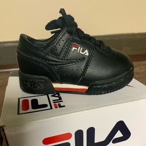 Black and red Fila toddler shoe worn